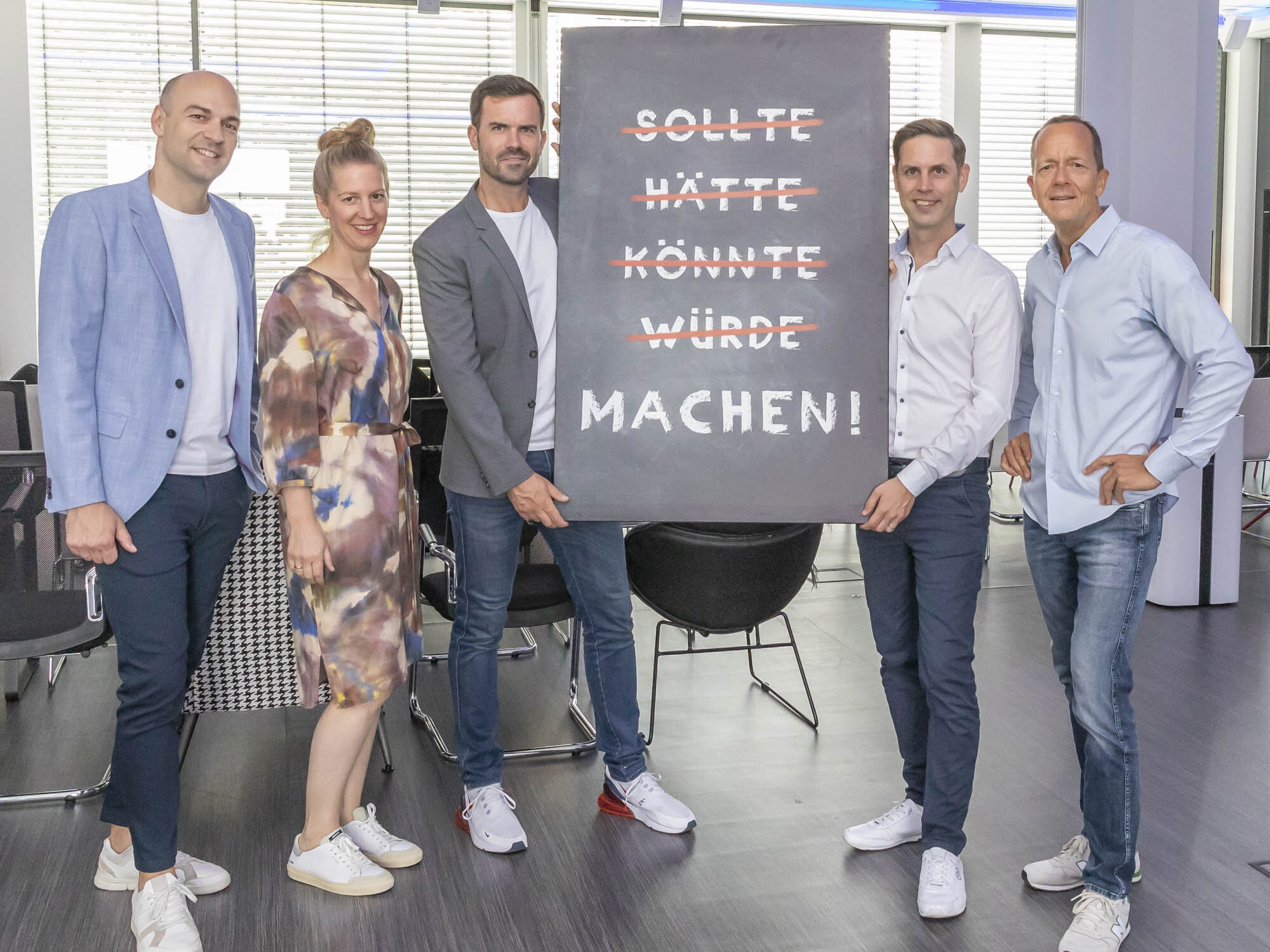 Team h&auml;lt eine Motivations-Tafel hoch